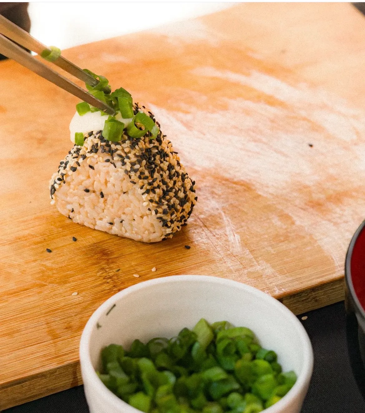 Onigiri recebendo cebolinha fresca