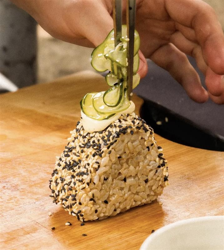 Onigiri sendo finalizado com pepino e gergelim
